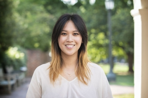 Headshot of Janet Kong-Chow wearing off-white v-neck top standing outside