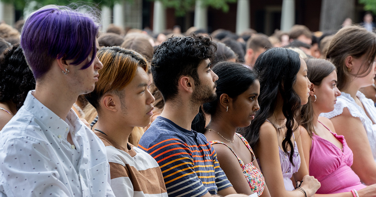 A diverse group of students sitting side-by-side during an event.