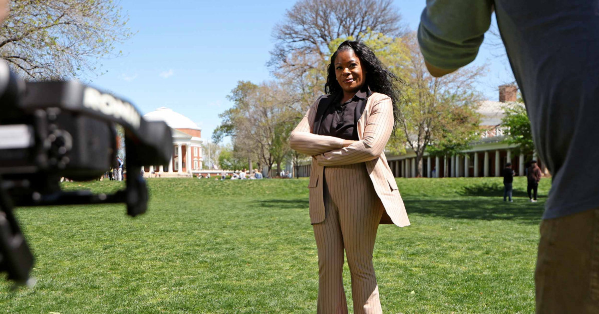 Krystal Porter stands with arms crossed in front of news cameras while on the UVA Lawn.