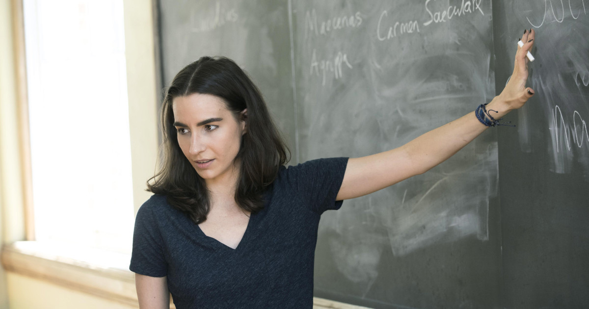 Professor Elizabeth Barnes standing in front of a chalkboard as she teaches.