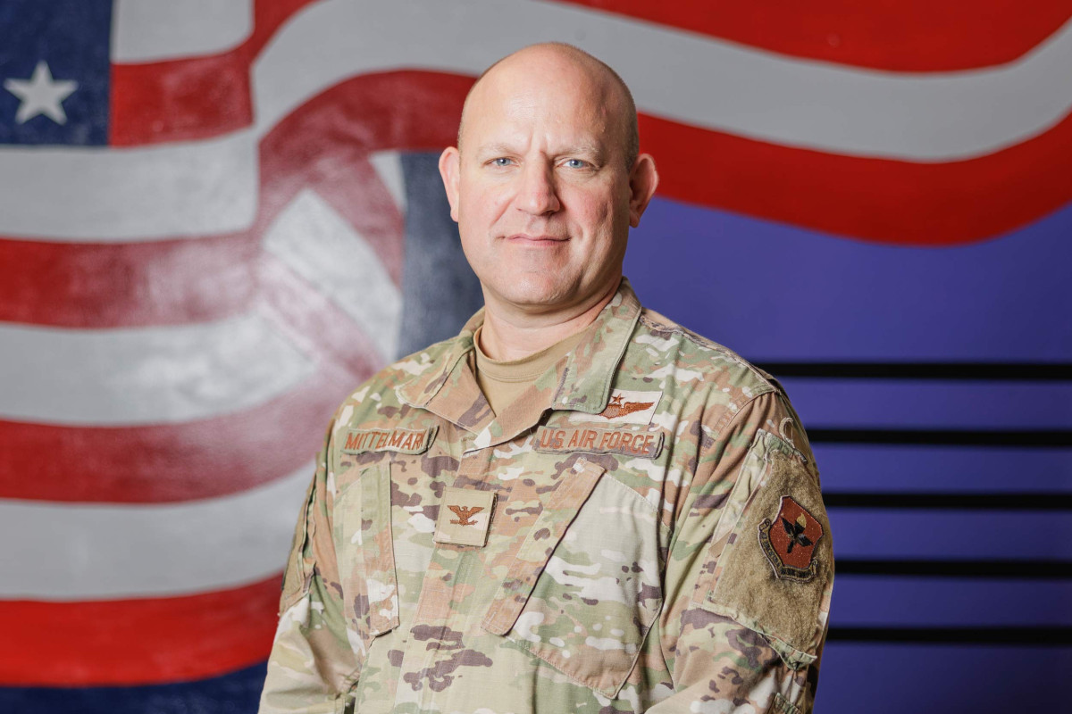 U.S Air Force Col. Cary Mittelmark in dress fatigues with American flag in background.
