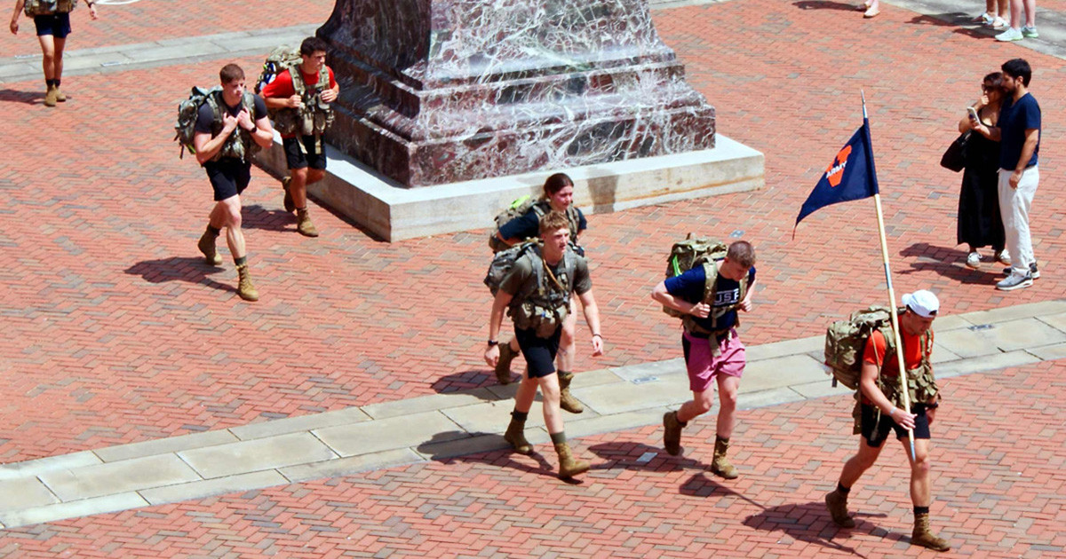 ROTC cadets marching across the steps of the Rotunda beneath the Thomas Jefferson statue.