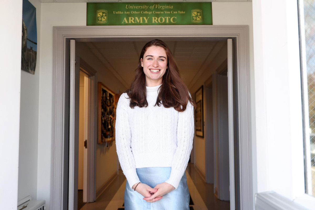 Rebecca Fitch stands in a doorway that has an Army ROTC banner above it.
