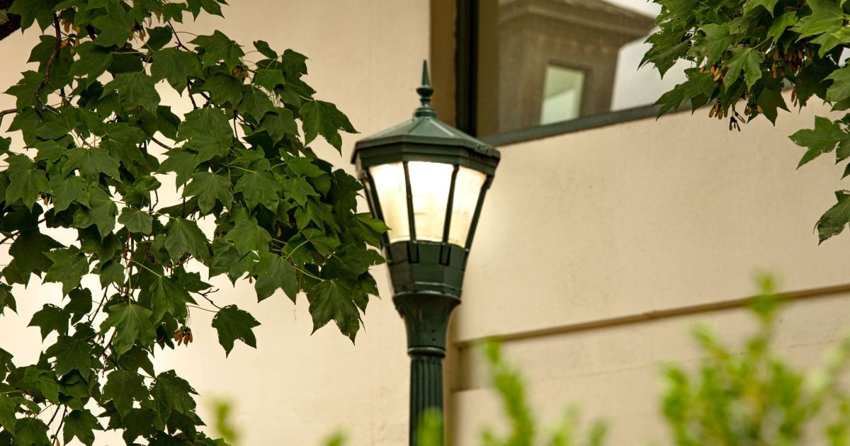 A closeup of a lighted street lamp on a pole