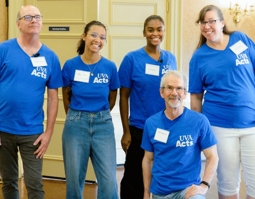 Five UVA Acts performers pose for a group photo, each wearing T-shirts with UVA Acts logo.