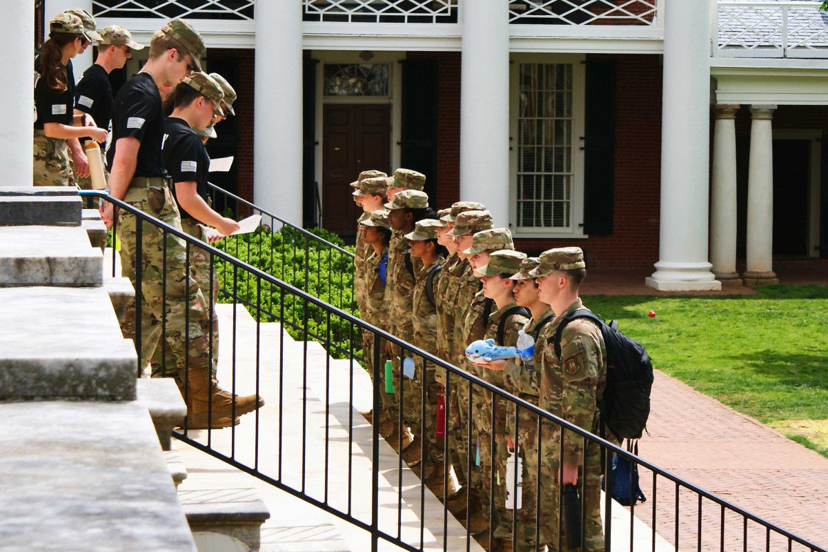 Two groups of ROTC students stand on the steps of the Rotunda facing each other while dressed in fatigues.