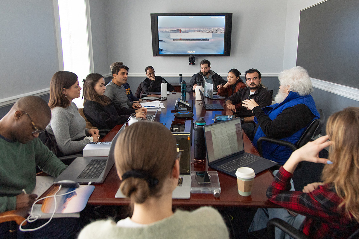 A diverse group of students sitting around a conference table.