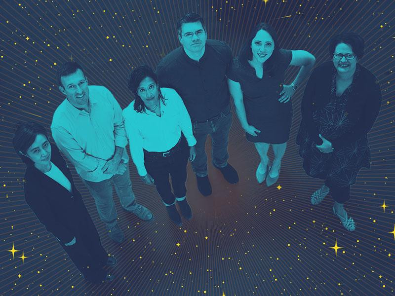 Aerial view of a group of astronomers who are looking up while surrounded by a starry dark background.