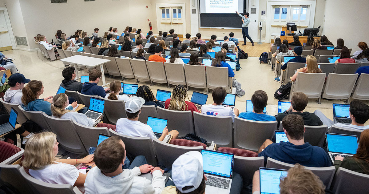 Aerial shot of a classroom full of students seated with laptops.
