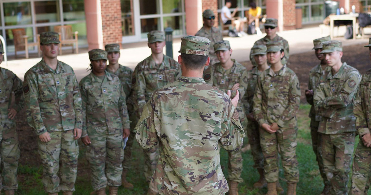 Air Force cadets stading in a line while commanding offer speaks to them.