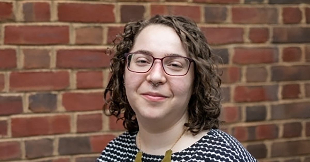 Headshot of Sarah Orsak in front of brick wall.