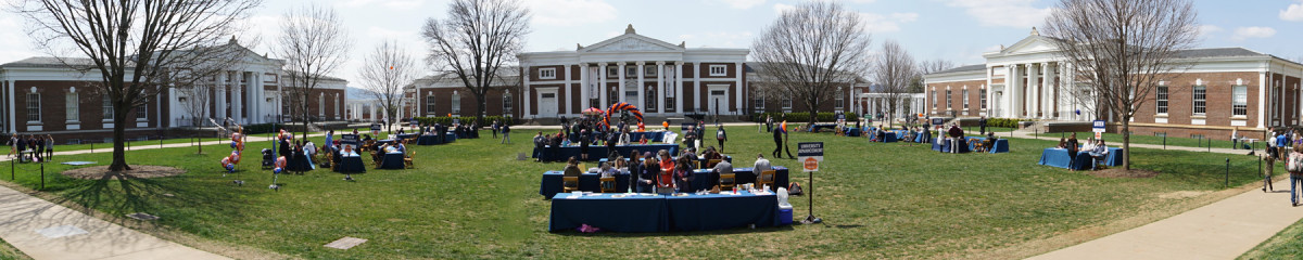 Panoramic view of the UVA's Old Cabell Hall courtyard, with a large gathering of   students attending an outdoor event.